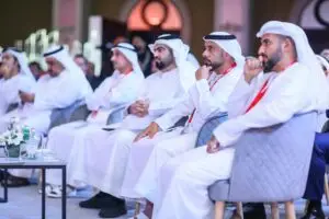 Home Page A business meeting in Dubai with men wearing traditional Middle Eastern clothing, focused and engaged.